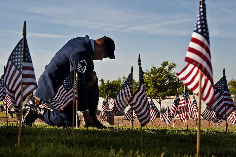 U.S. Air Force Master Sgt. Robert Lilly, a joint tactical air controller with the 57th Operations Group, pays tribute to a fallen veteran May 28, 2013, at the Southern Nevada Veterans Memorial Cemetery in Boulder City, Nev. Airmen stationed at Nellis Air Force Base volunteered to place flags over cemetery plots as part of Memorial Day ceremonies. (DoD photo by Senior Airman Daniel Hughes, U.S. Air Force/Released). Original public domain image from Flickr