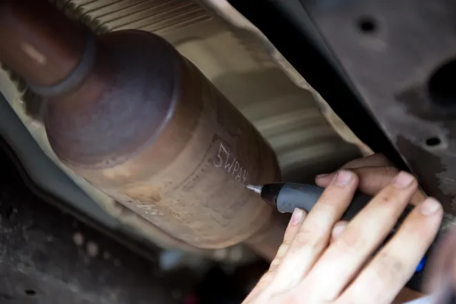 Engraving tool being used to etch a license plate number onto a catalytic converter