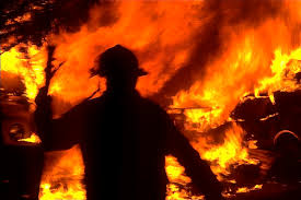 Image of unknown firefighter attempting to tame the flames of the 1991 Oakland Hills Firestorm.