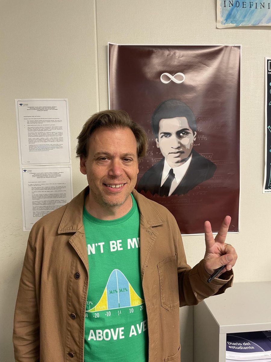 John Thayer in his classroom giving a peace sign
